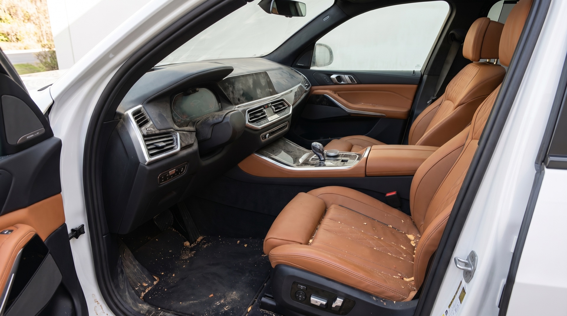 SUV interior before detailing — dusty dash, debris on carpet